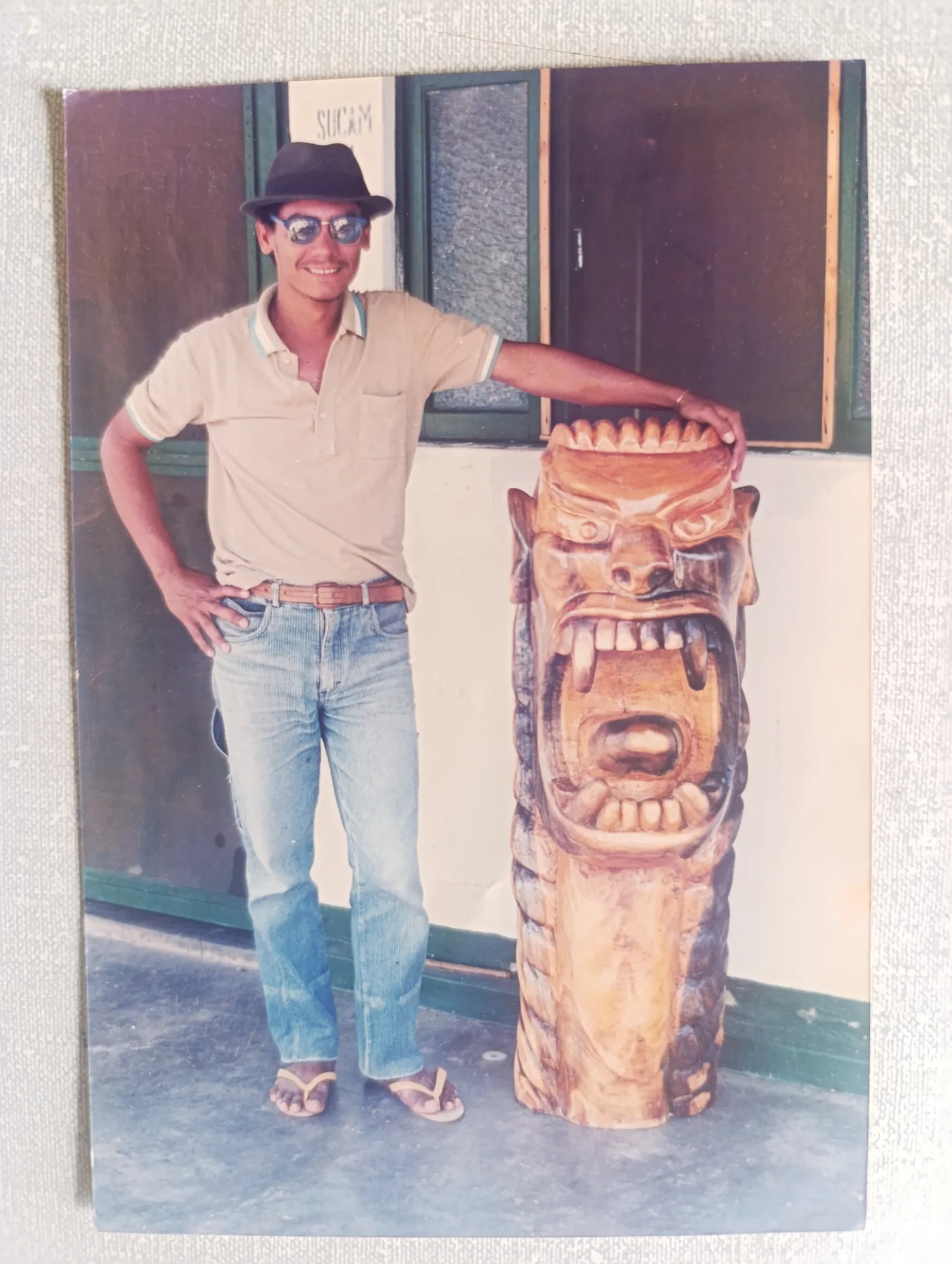 Beltrão Artesão jovem, em pé ao lado de uma carranca monumental, anos 1980